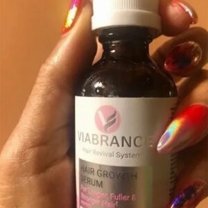 Hand holding Viabrance Hair Growth Serum bottle with colorful nails.